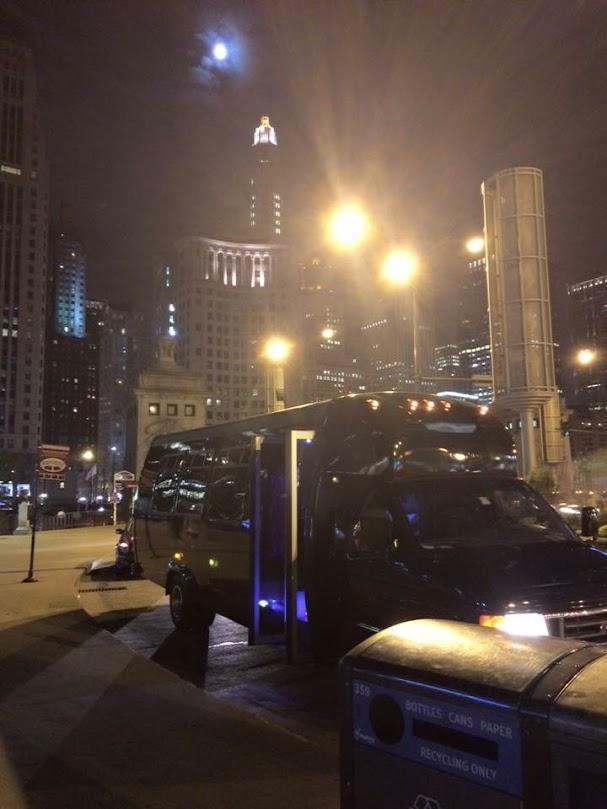 Stop & Go Airport Shuttle Service, Inc. party bus against the Chicago skyline at night
