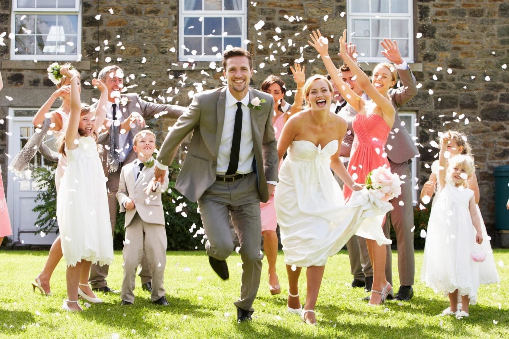 Joyful wedding party celebrating outside the venue