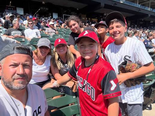 A family enjoying a Chicago White Sox game at Rate Field, served by Stop & Go Airport Shuttle Service, Inc.