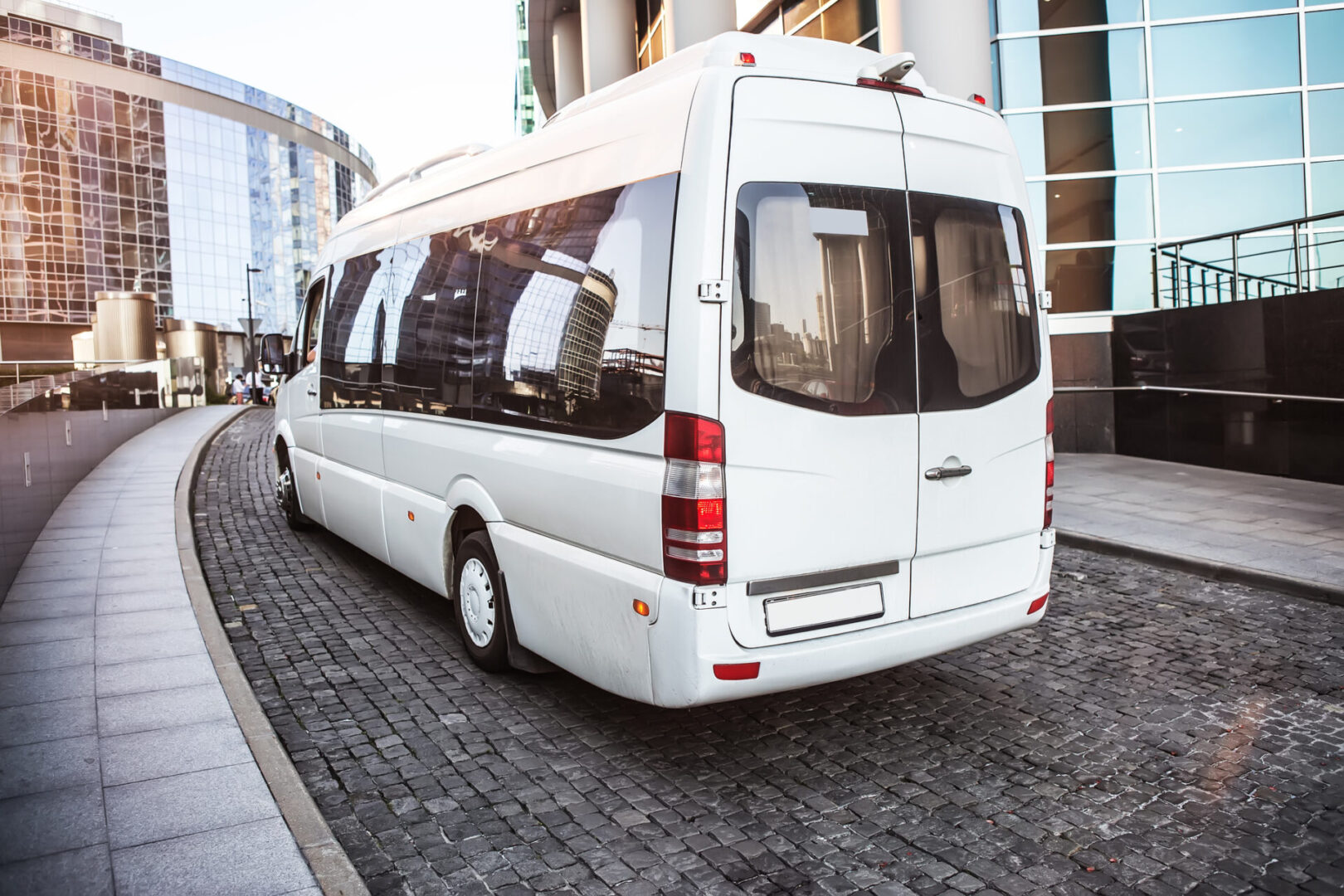 A white bus is parked on the side of the street.