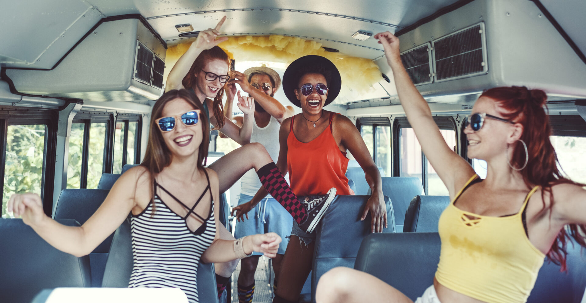 A group of people standing on top of a bus.