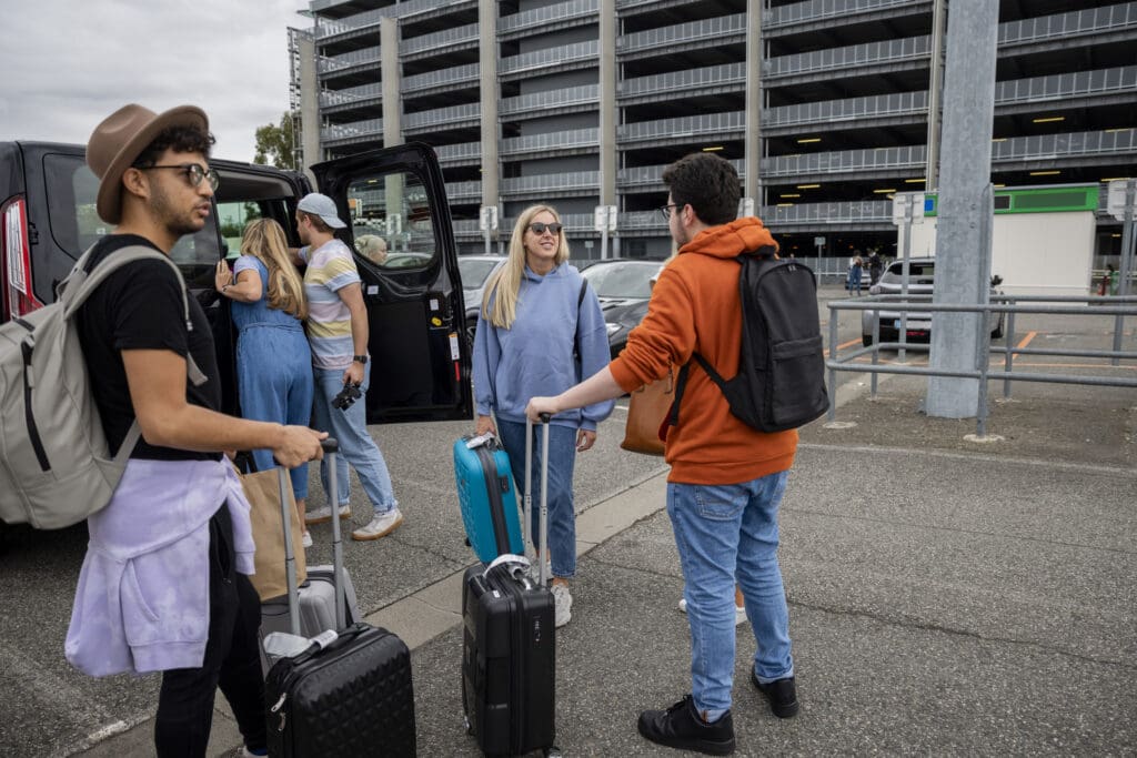 A group of people standing around with luggage.