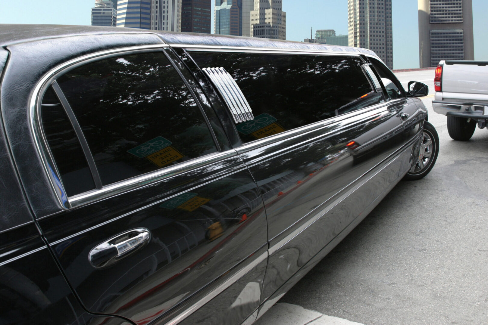 A black limo is parked on the side of the road.