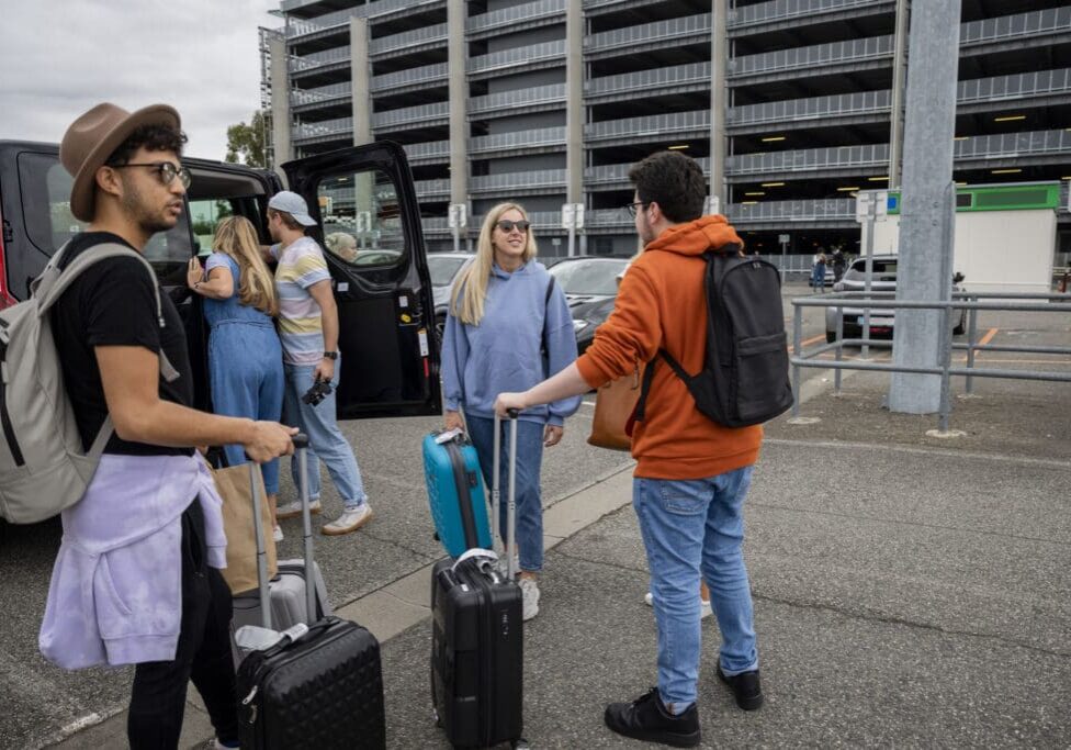 A group of people standing around with luggage.